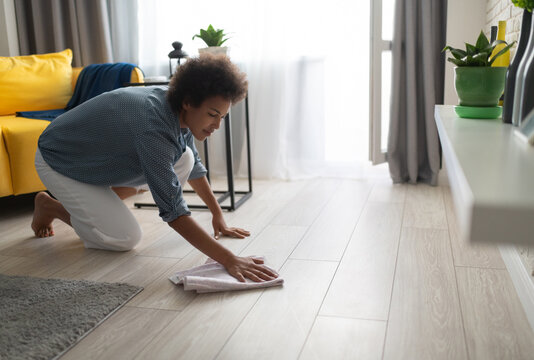 Black woman washing floor at home