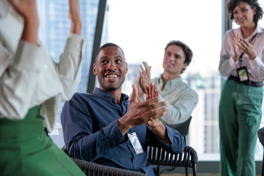 Diverse group of people clapping at a business meeting.