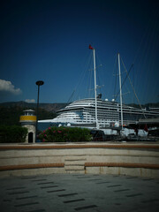 Fototapeta premium Large cruise ship docked at a harbor with small lighthouse