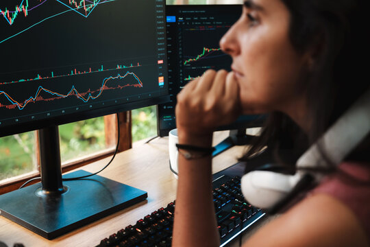 woman Trading Stock on Multiple Screens at Home office setup