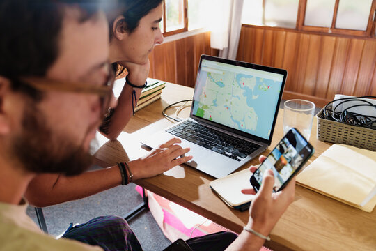 Couple Planning a Trip Together with Laptop and Phone