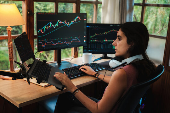 woman Trading Stock on Multiple Screens at Home office setup