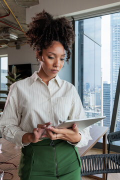 Woman with digital tablet in modern office setting.