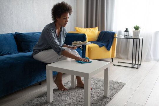 African American female cleaning table