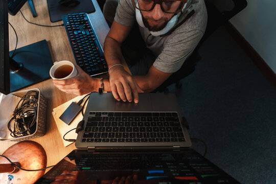 Man Analyzing Stock Charts on Multiple Screens at Night
