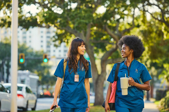 Two Nurses Walk on a City Street Together