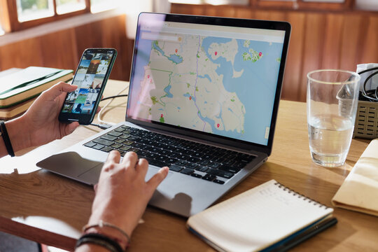 Woman Planning a Trip with Laptop and Smartphone at Home