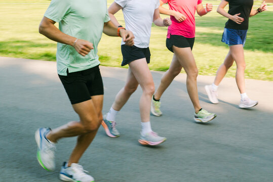 Group Runs Together on a Park Path During Sunny Afternoon
