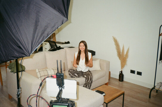 Woman Sitting on Sofa in Living Room During Video Recording 