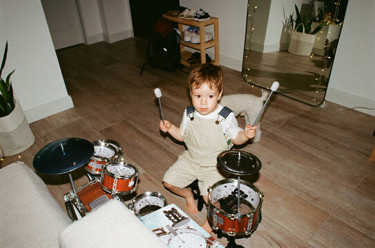 Child Playing Drums in a Living Room