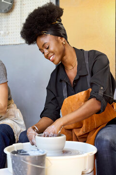 Woman Shapes Clay in Pottery Studio With Joy