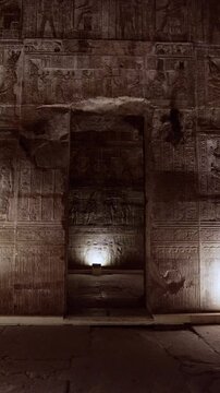 Dendera temple corridor with illuminated hieroglyphic walls and ritual reliefs in Egypt, ancient sacred chamber with dramatic lighting on carved sandstone surfaces.