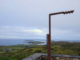 Fototapeta premium The iconic rusty metal Sky Road sign overlooking the spectacular coastal landscape and islands in Connemara, County Galway, Ireland.