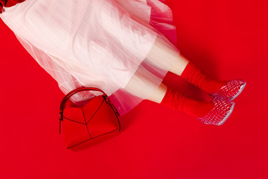 Woman wearing white skirt, red socks, and handbag