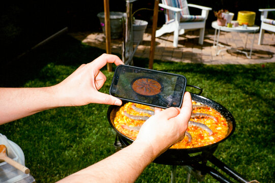 Man Taking Photo of Paella