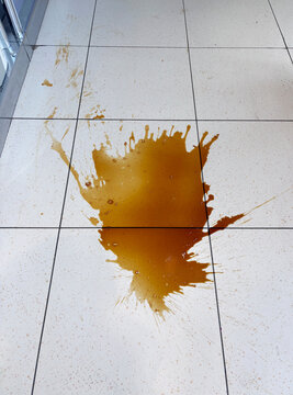brown liquid spilled on floor
