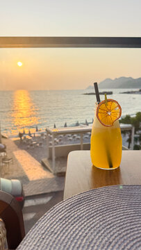 Golden hour glow over a seaside drink and distant mountains