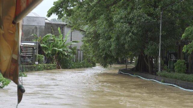 view of highest level of water flooded in canal over the bothside of canel's bankside while water flowing through phuket city old town after heavy raining