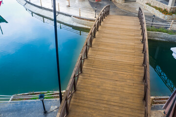Fototapeta premium A Wooden bridge with a curved design,wooden bridge for bicycles over river,rest and holiday,travel nature concept.