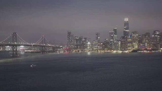 Glowing San Francisco Skyline Panorama Across Bay at Night With Hazy Sky