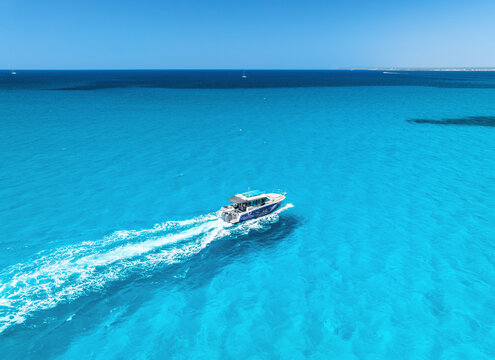 Aerial drone view of floating luxury yacht in blue sea on sunny day. Summer vacation. Mallorca island, Spain. Top down view of boat, sea, turquoise water. Travel. Tropical landscape. Yachting. Cruise