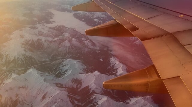 Airplane wing over glacier and Canadian Rockies near Banff, aerial view