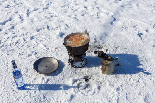 Fish soup cooking on ice with vodka in Russia.