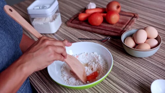 Woman's hands mixing flour and egg for homemade pasta