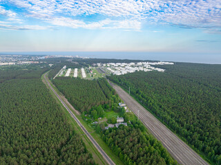 Naklejka premium Aerial view of Ventspils oil storage terminals, railway corridor, pine forest and Baltic Sea coastline in Latvia