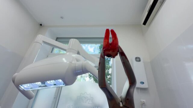 A bloody tooth hangs in sharp metal forceps inside a bright dental clinic. Looking up at it triggers a shocking mix of fear and deep relief.
