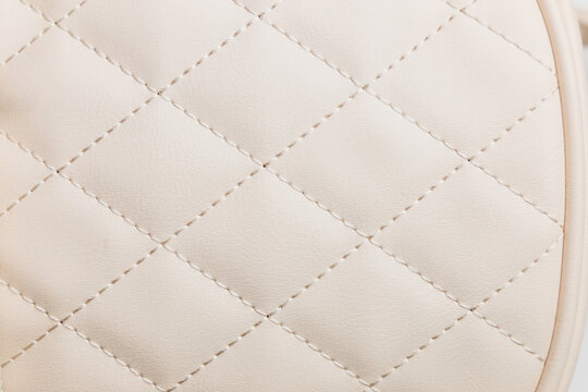 Close-up view of a leather textured background showing a quilted design on a light colored surface