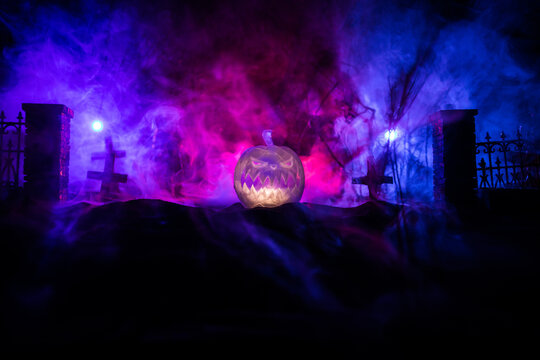 Halloween concept. Creepy silhouette in the dark corridor with pumpkin head. Toned light with fog on background.