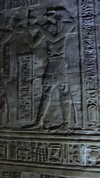 Dendera temple interior sanctuary with illuminated hieroglyphic walls and ritual reliefs in Egypt, ancient sacred chamber with dramatic lighting on carved sandstone surfaces.