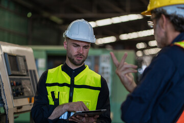 Fototapeta premium Workers Factory or Engineering work at factory site check up machine or products in site. Foreman or Technician checking Material or Machine on Plant. Heavy industry factory concept.