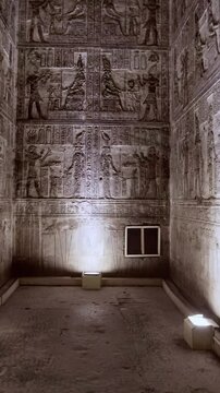 Dendera temple interior sanctuary with illuminated hieroglyphic walls and ritual