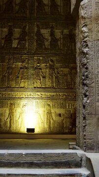 Ancient stone hall inside the Dendera Temple Complex with detailed hieroglyphic