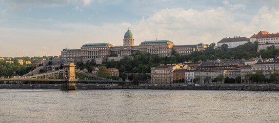 Panoramic view of Buda Castle and Szechenyi Chain Bridge over the Danube river during golden hour...