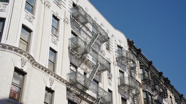 Iconic fire escapes on brownstones and pre war architectural details of a historic New York City building facade creating a classic Manhattan street scene