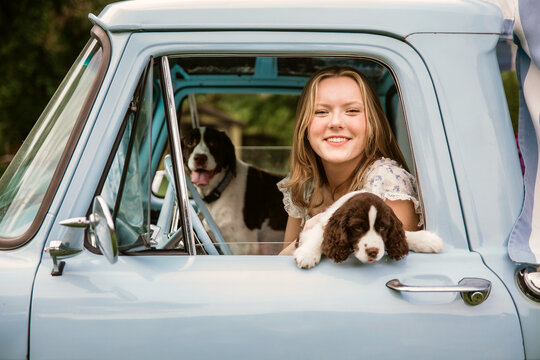young woman in truck with dogs