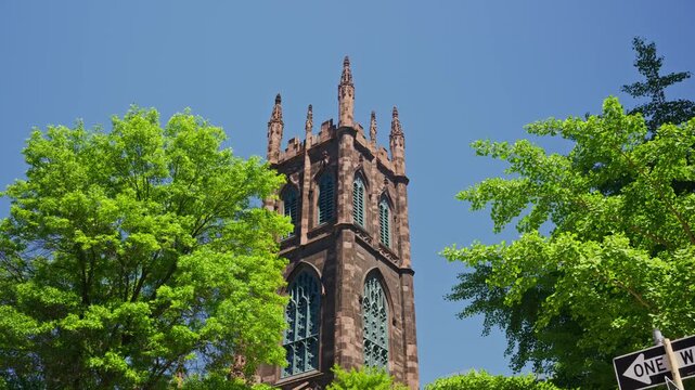 First Presbyterian Church tower standing tall in Greenwich Village historic district on Fifth Avenue in New York City, vibrant clear blue spring sky in Manhattan