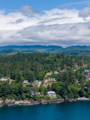 Fototapeta premium Aerial View of Coastal Houses and Evergreen Forest at Otter Point, Sooke, Vancouver Island, British Columbia, Canada