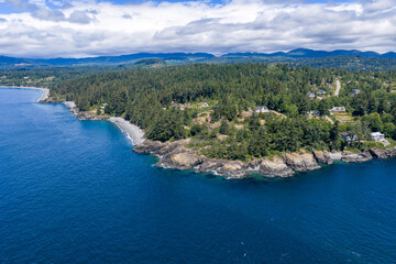Fototapeta premium Aerial View of Rocky Coastline and Evergreen Forest at Otter Point, Sooke on Vancouver Island