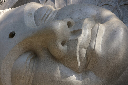 Serene close-up front view of the stone face of the Reclining Buddha statue at Long Son Pagoda in Nha Trang, Vietnam.