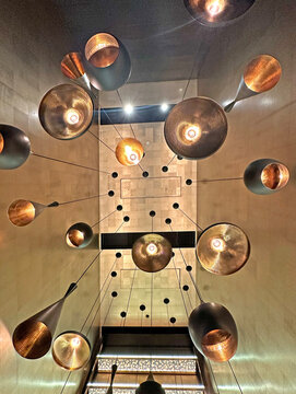 Modern abstract chandelier with multiple metallic pendant lights hanging indoors