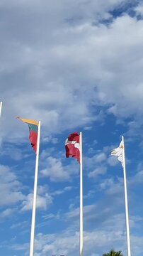 National flags of all European Union member states waving in the breeze against a blue sky with clouds, symbolizing unity, international relations, negotiations, and the future of Europe