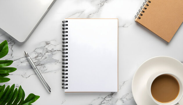 Flat lay of an open blank notebook and silver pen beside a laptop and coffee cup on a marble desk, conveying a productive morning work session