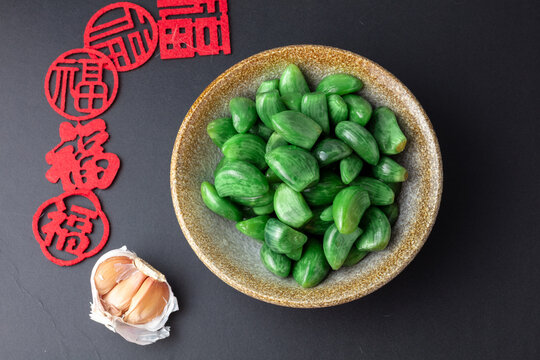 Green Laba Garlic with Chinese New Year Decoration on Dark Background