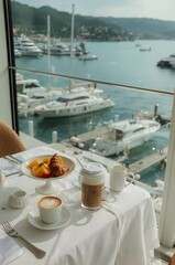 Fototapeta premium Breakfast on a Table by the Water With Boats in a Harbor During the Day