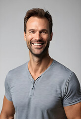Fototapeta premium Smiling adult man in casual grey shirt with neutral background