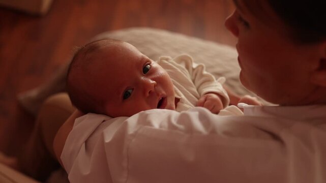 mother is holding the newborn baby in her arms at home